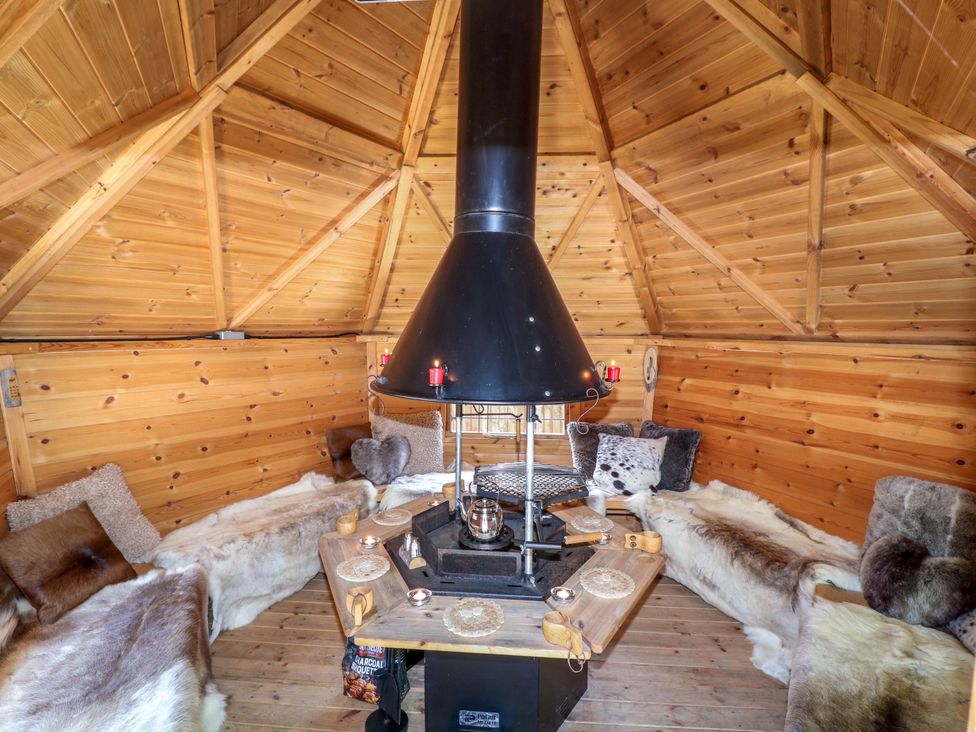 A snug with a round table and a stove at Shepherds Hut in South Hykeham