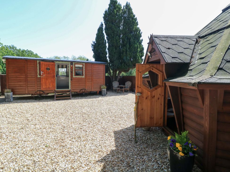 An outdoor area with wooden cabins and a gravel path at Shepherds Hut in South Hykeham
