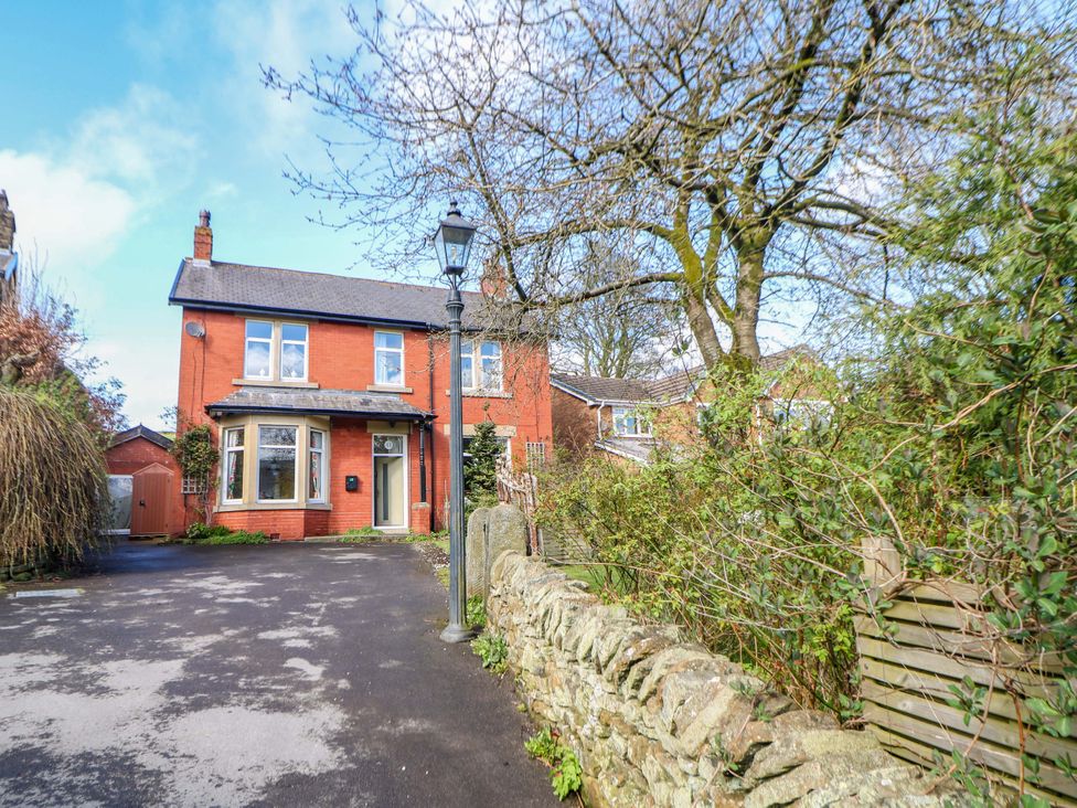 A house with a garden and stone wall at Glenside Lodge in Chapel-En-Le-Frith