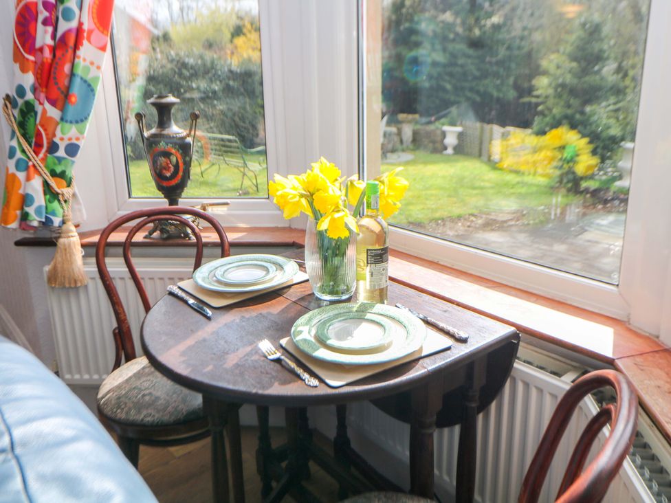 A dining table set with plates and flowers at Glenside Lodge in Chapel-En-Le-Frith