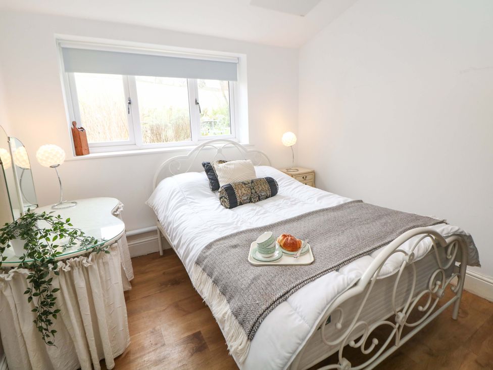 A bedroom with a bed and mirror at Glenside Lodge Chapel-En-Le-Frith