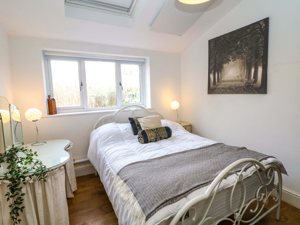 A bedroom with a bed and a table at Glenside Lodge in Chapel-En-Le-Frith