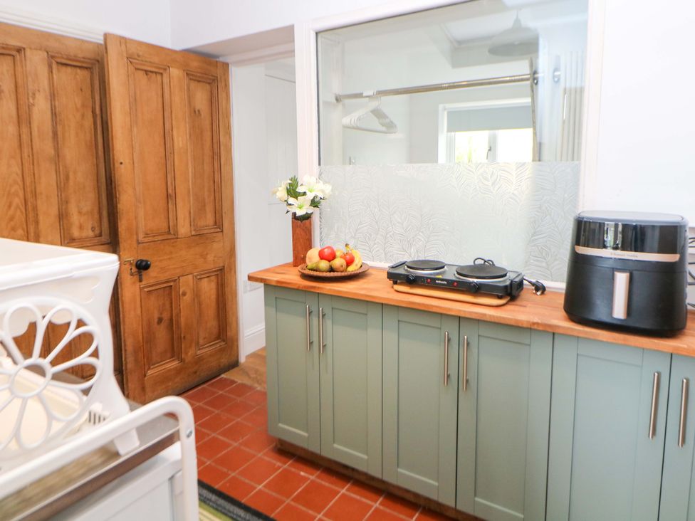 A kitchen with a wooden countertop and kitchen appliances at Glenside Lodge in Chapel-En-Le-Frith