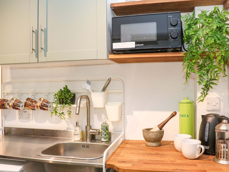 A kitchen with a sink and microwave at Glenside Lodge in Chapel-En-Le-Frith