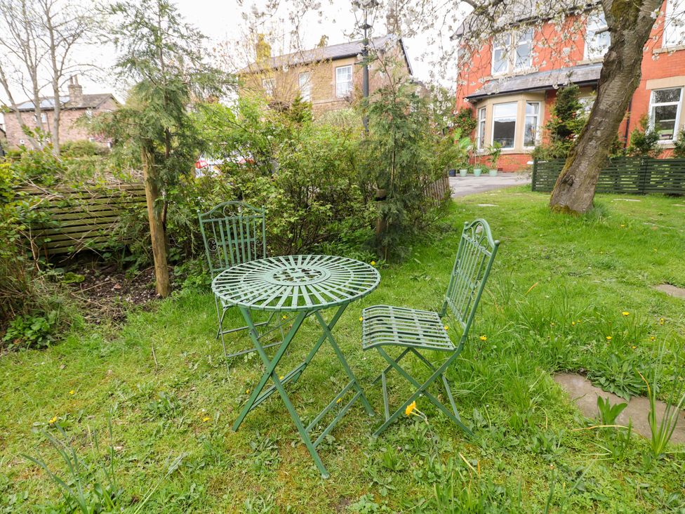 A garden with a table and chairs at Glenside Lodge Chapel-En-Le-Frith