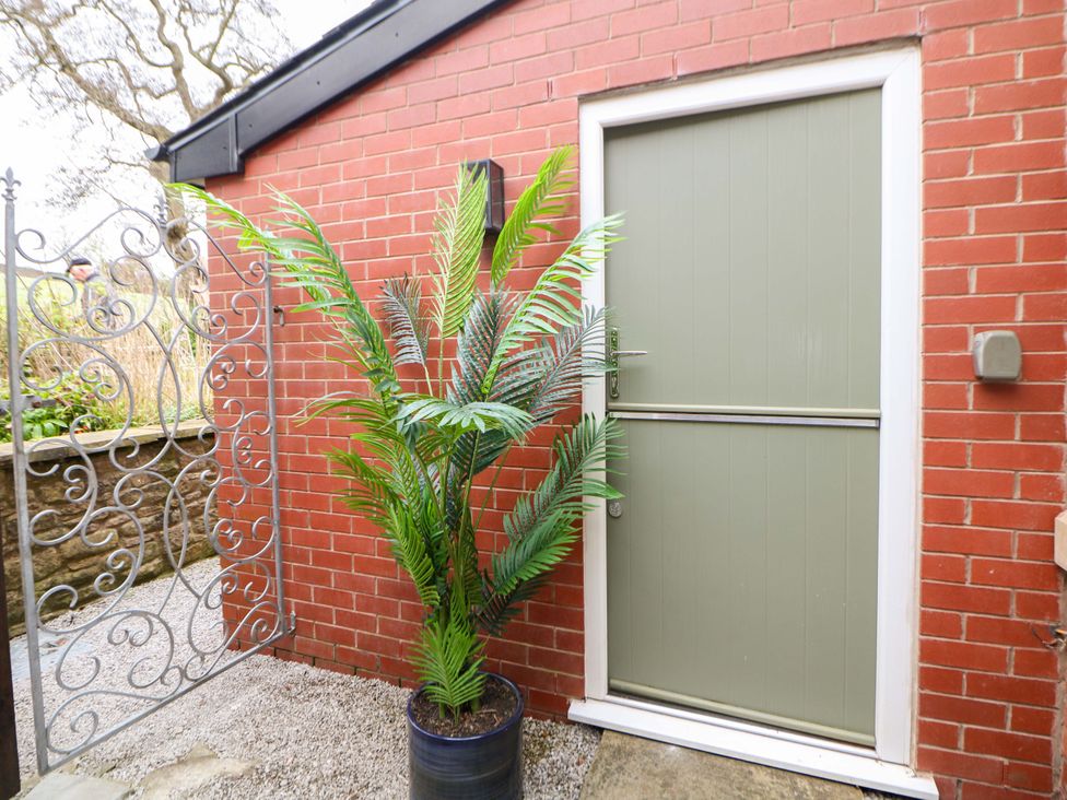 An outdoor area with a door, plant, and gate at Glenside Lodge in Chapel-En-Le-Frith