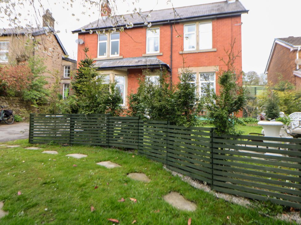 A house with a green fence and garden at Glenside Lodge in Chapel-En-Le-Frith