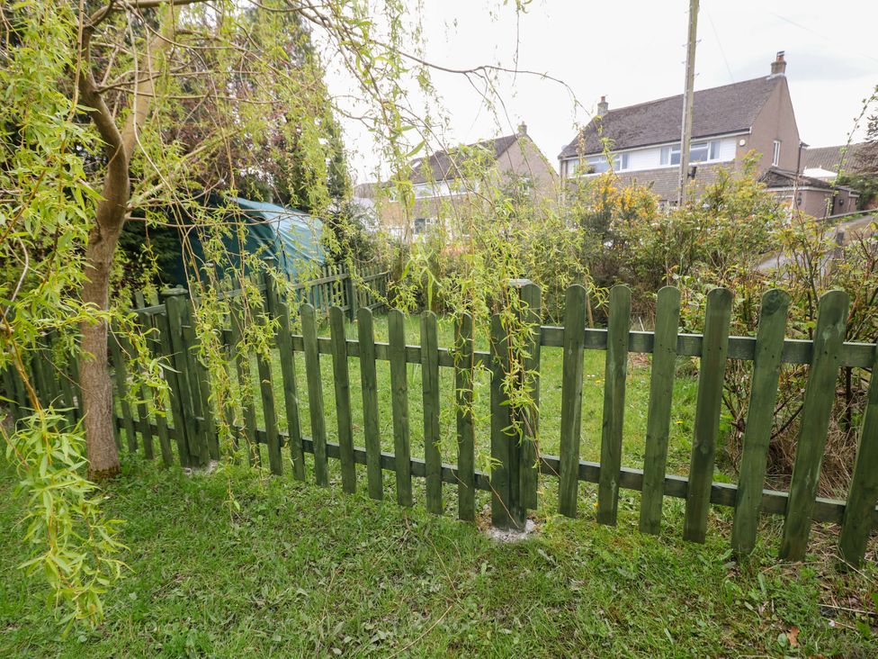 A garden with a wooden fence and a shed at Glenside Lodge in Chapel-En-Le-Frith