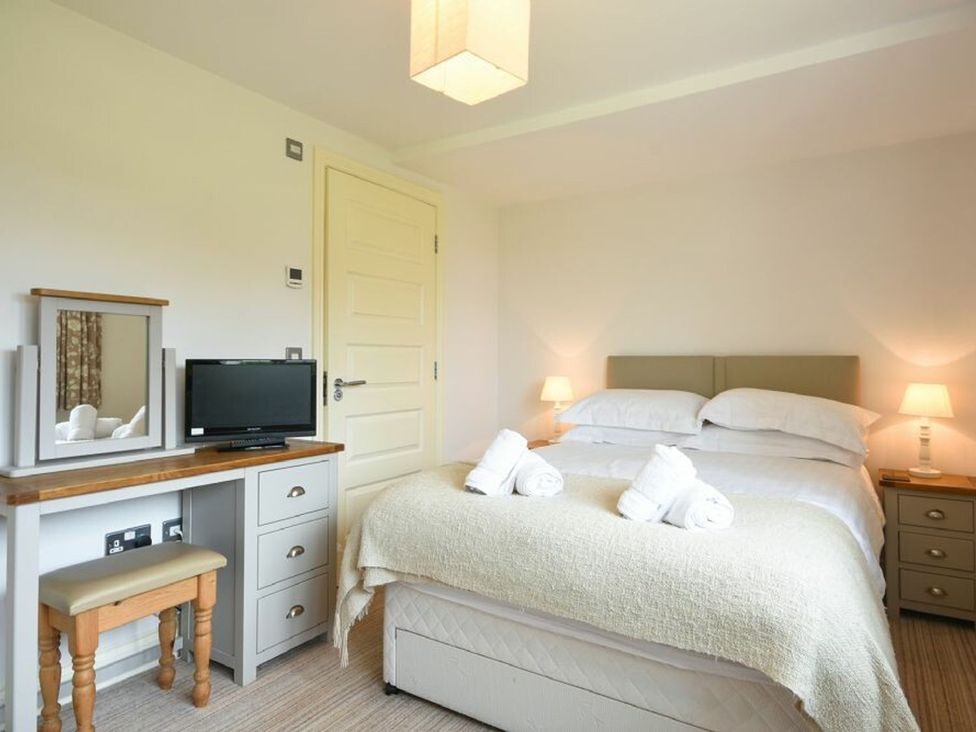 A bedroom with a bed and a television at Northrawe in Bamburgh