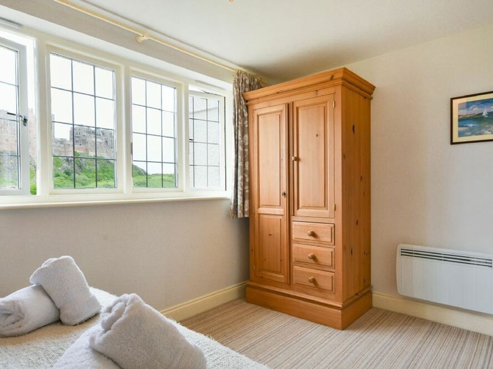 A bedroom with a wardrobe and towels at Northrawe in Bamburgh