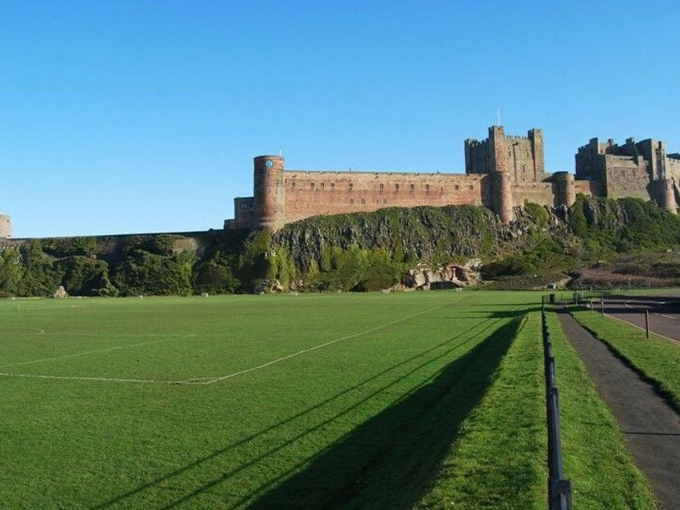 A castle overlooking a soccer field at Northrawe in Bamburgh