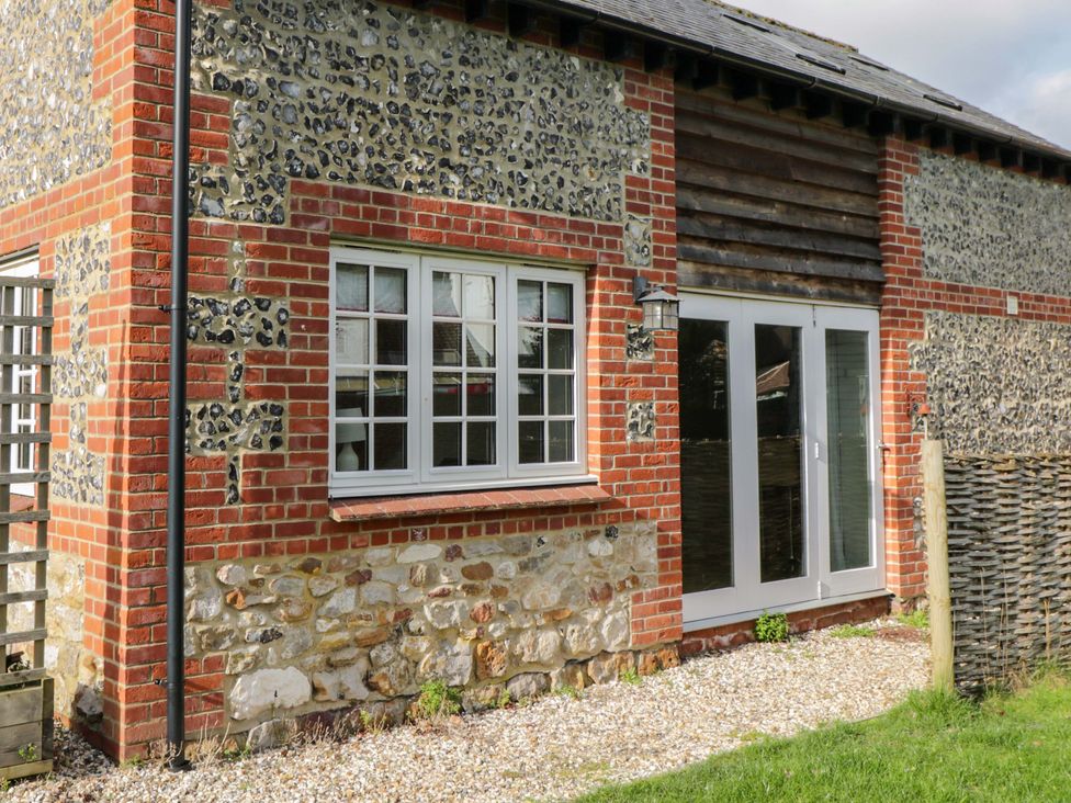 An exterior view of a cottage with a brick and flint wall at The Barn at Myrtle Cottage 
