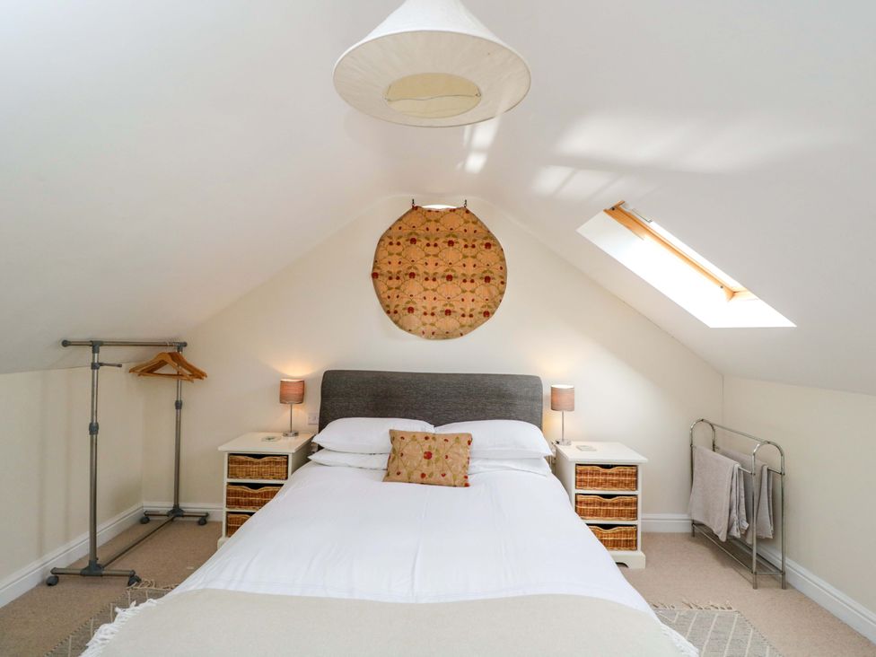 A bedroom with a bed and bedside table at The Barn at Myrtle Cottage