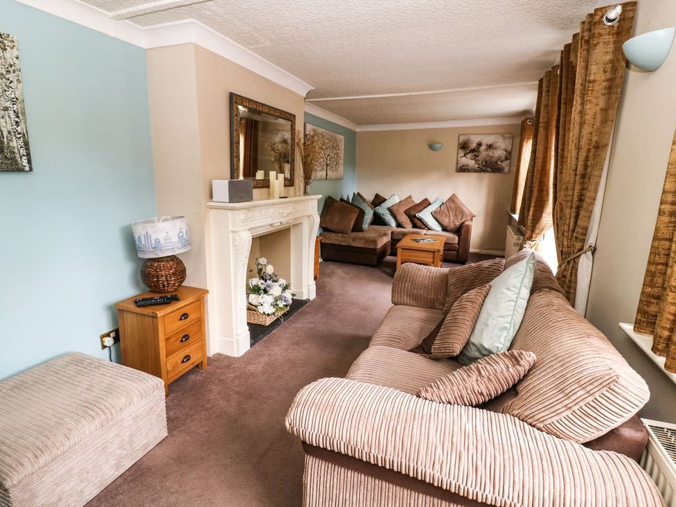 A living room with a sofa and fireplace at Blacksmiths Retreat in York