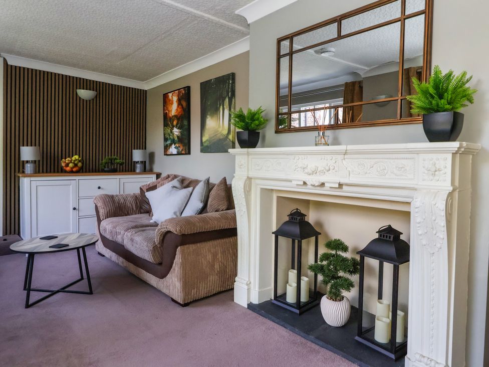 A living room with a sofa and fireplace at Blacksmith Mews in York