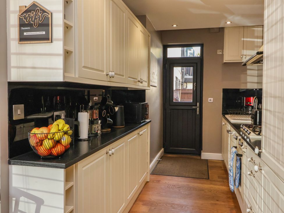 A kitchen with cabinets and a door at Blacksmith Mews in York