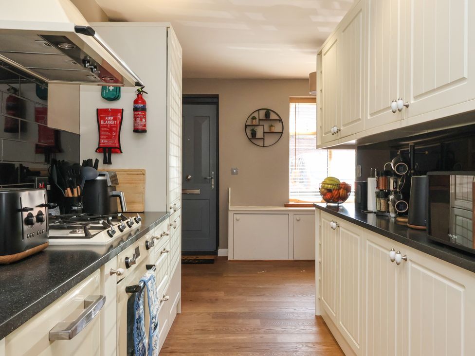 A kitchen with a stove, oven, and cabinets at Blacksmith Mews, York