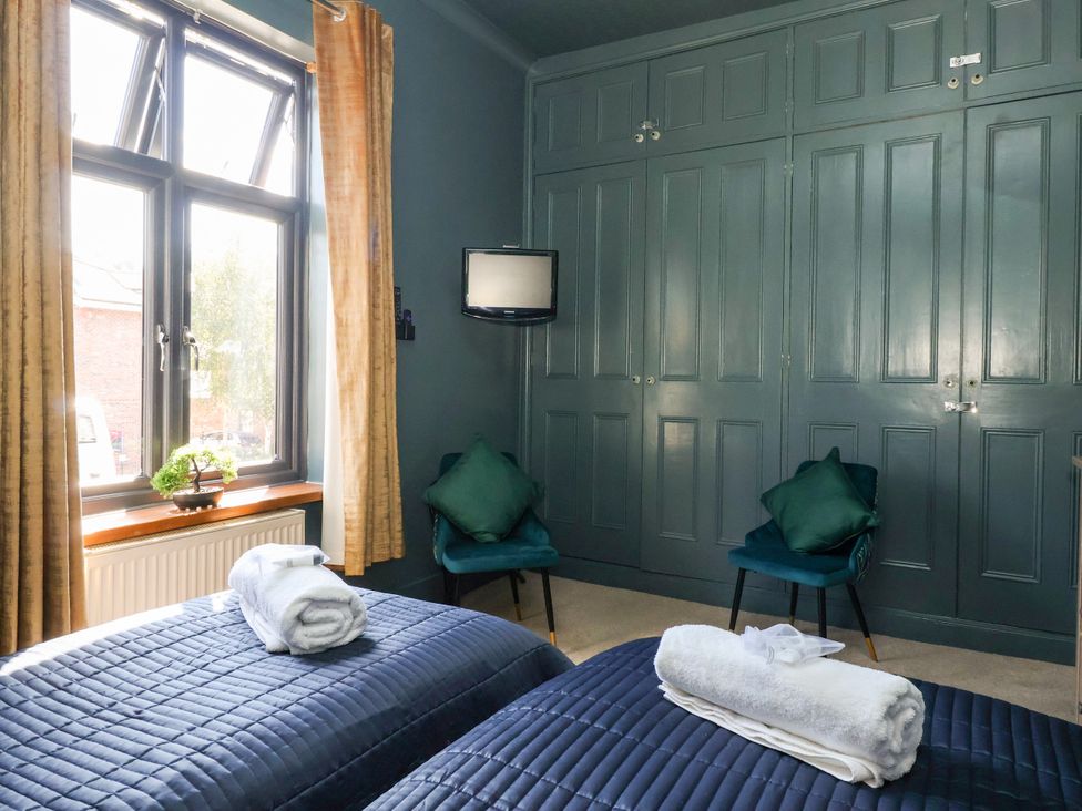 A bedroom with two beds and a television at Blacksmith Mews in York