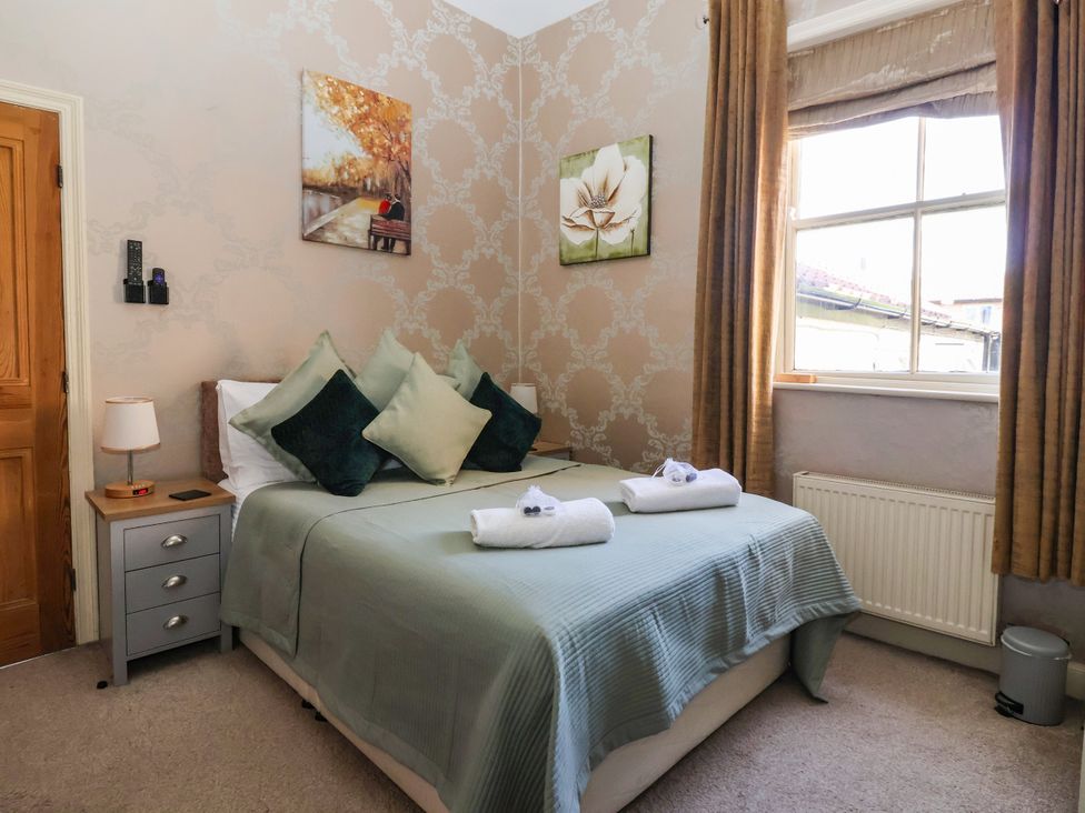A bedroom with a bed and nightstand at Blacksmith Mews York