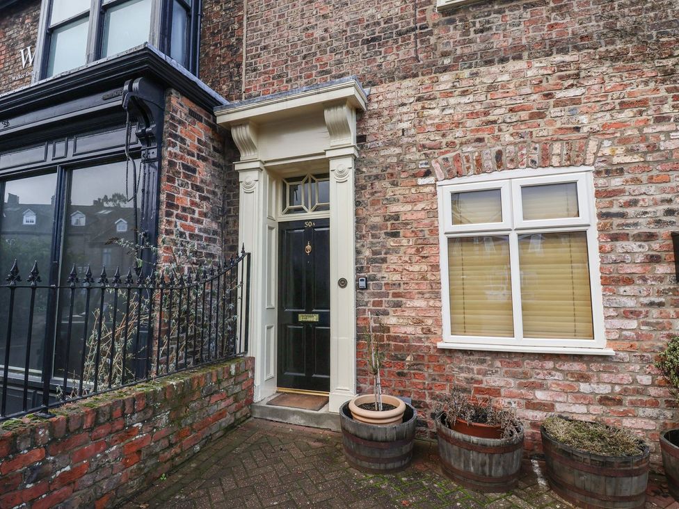 A doorway and window with plants outside at Blacksmiths Mews in York
