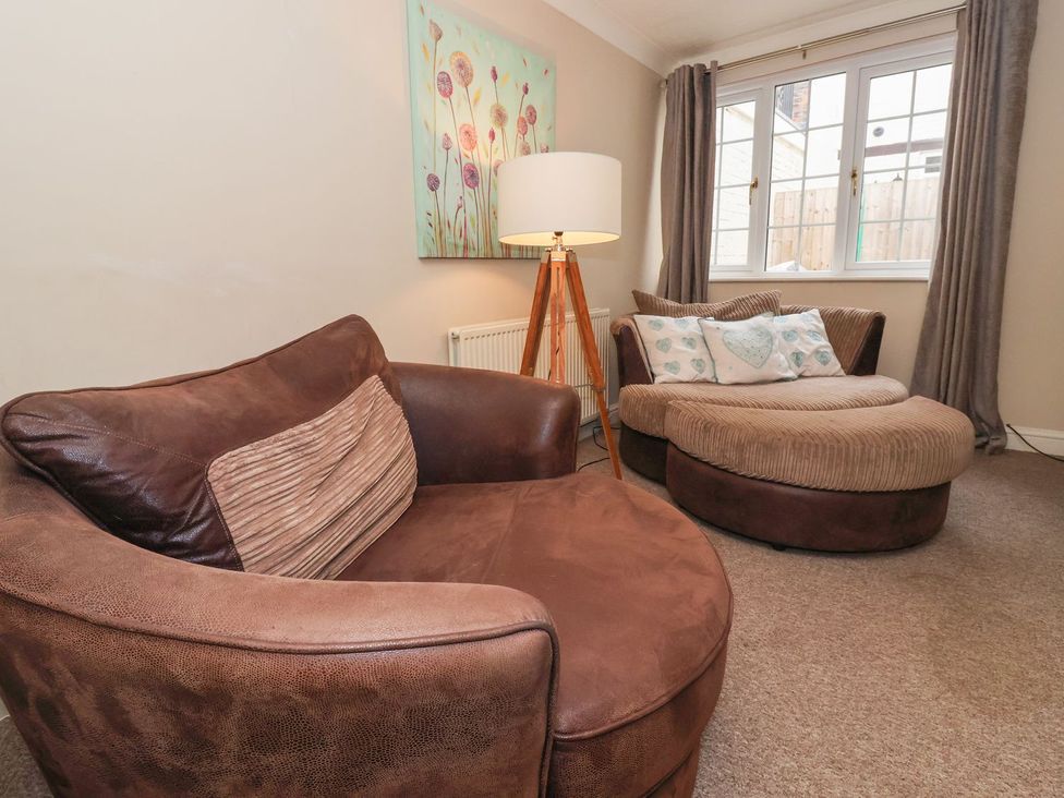 A living room with an armchair and footstool at Blacksmiths Mews in York
