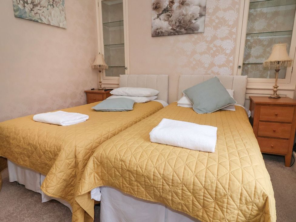 A bedroom with two beds and a bedside table at Blacksmiths Mews in York