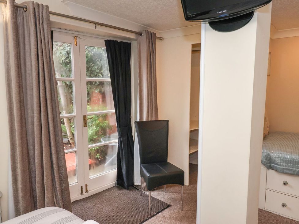 A bedroom with a chair and a door leading outside at Blacksmiths Mews in York