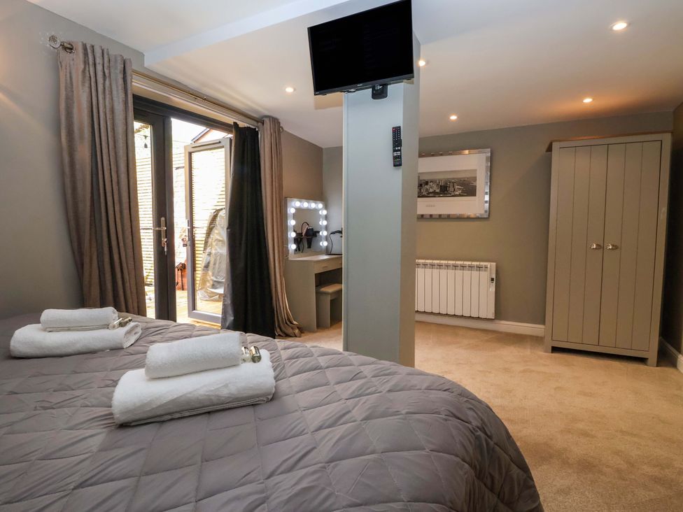 A bedroom with a bed and a dressing table at Blacksmiths Retreat in York