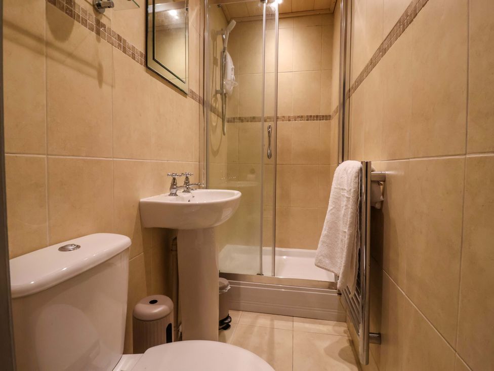 A bathroom with a shower, toilet, and sink at Blacksmiths Retreat in York