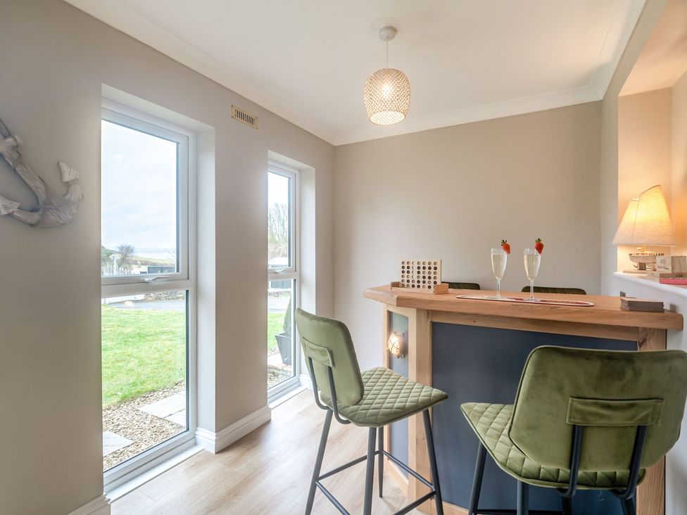 A bar area with stools and windows at Broadsands in Paignton