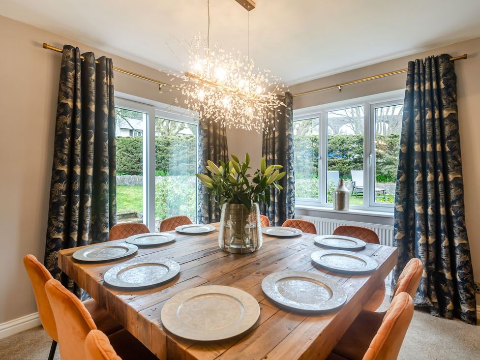 A dining room with a table set for meals at Broadsands in Paignton