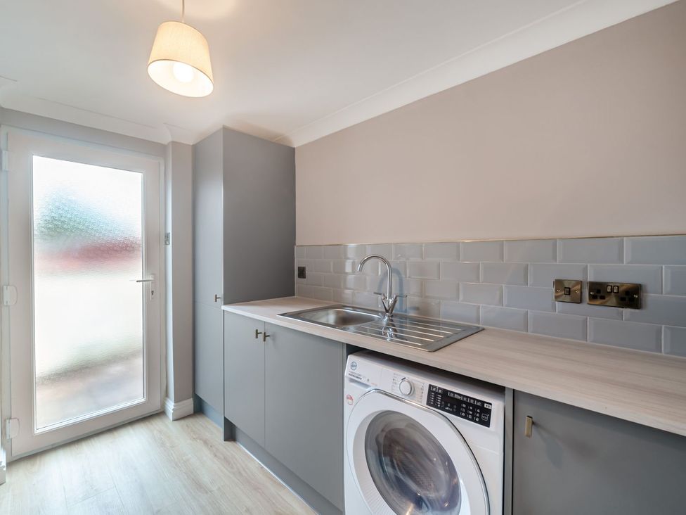 A kitchen with a sink and washing machine at Broadsands Paignton
