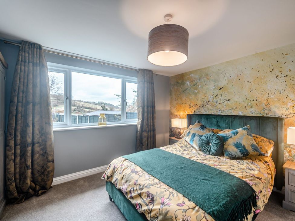 A bedroom with a bed and window at Broadsands in Paignton