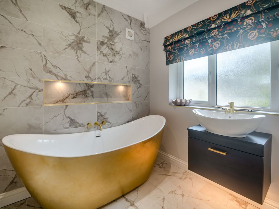 A bathroom with a bathtub and sink at Broadsands in Paignton