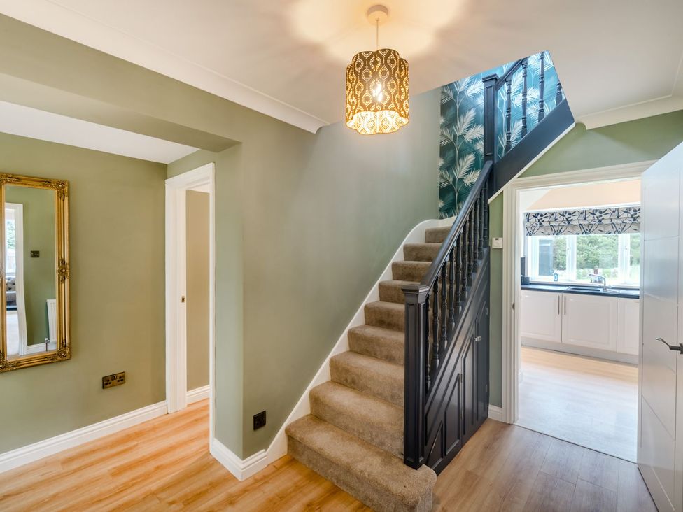 A staircase and mirror in a hallway at Broadsands in Paignton