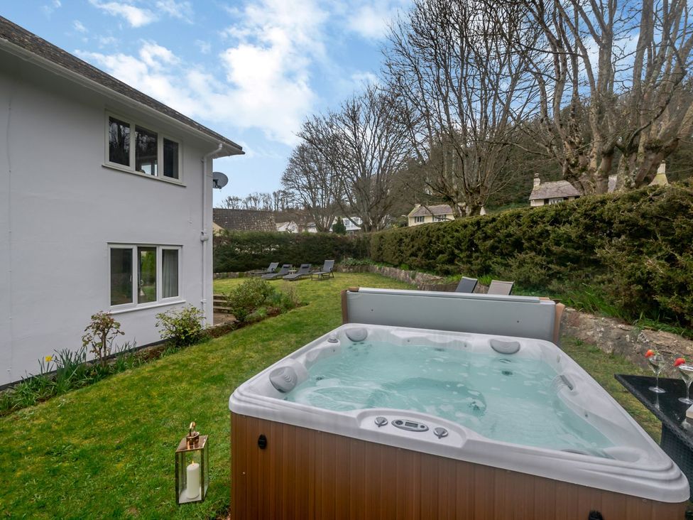 A garden with a hot tub and lounge chairs at Broadsands in Paignton