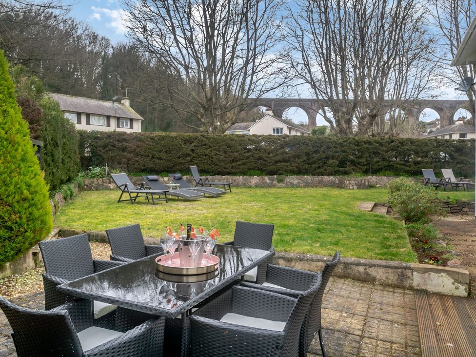 A garden with a table and chairs at Broadsands in Paignton