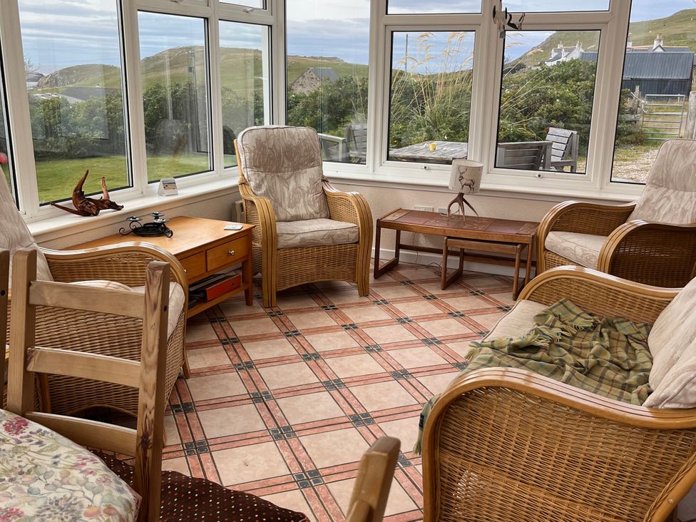 A conservatory with chairs and a table at An Grianan in Lairg