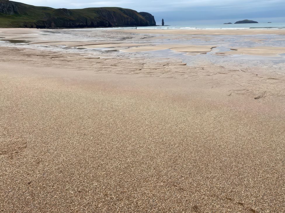 A beach with sand and water at An Grianan in Lairg
