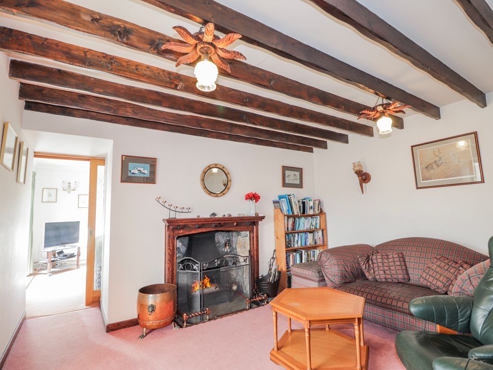 A living room with a fireplace and sofa at An Grianan Kinlochbervie