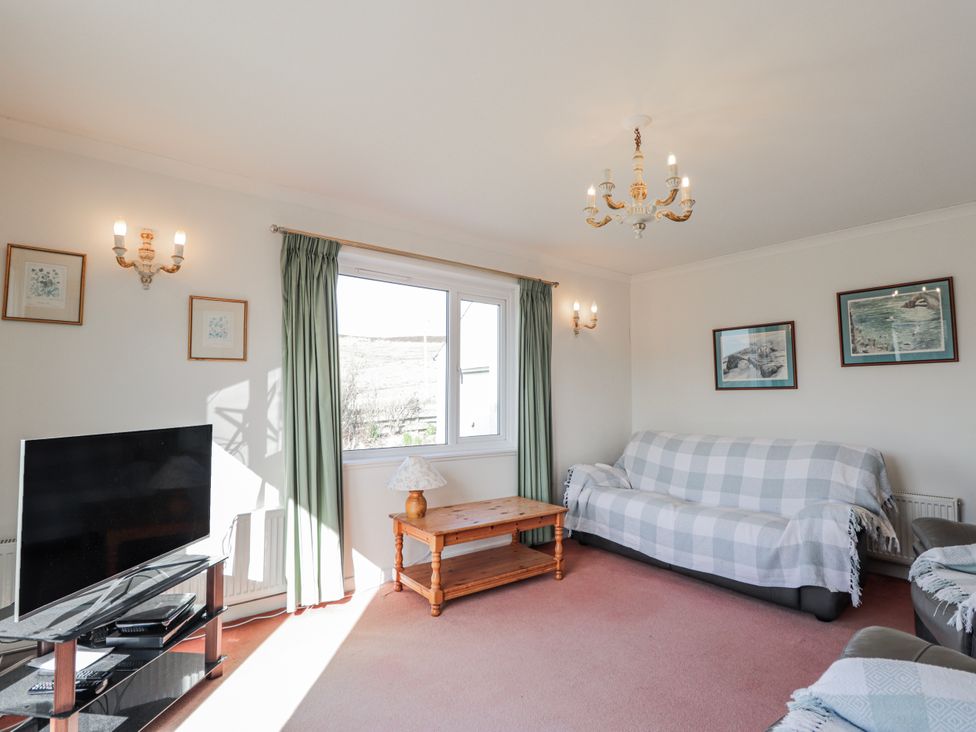 A living room with a sofa and television at An Grianan in Kinlochbervie