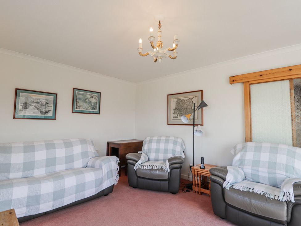 A living room with sofas and wall art at An Grianan in Kinlochbervie