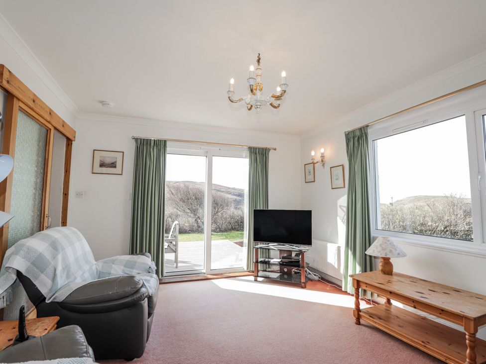 A living room with a sofa and television at An Grianan in Kinlochbervie