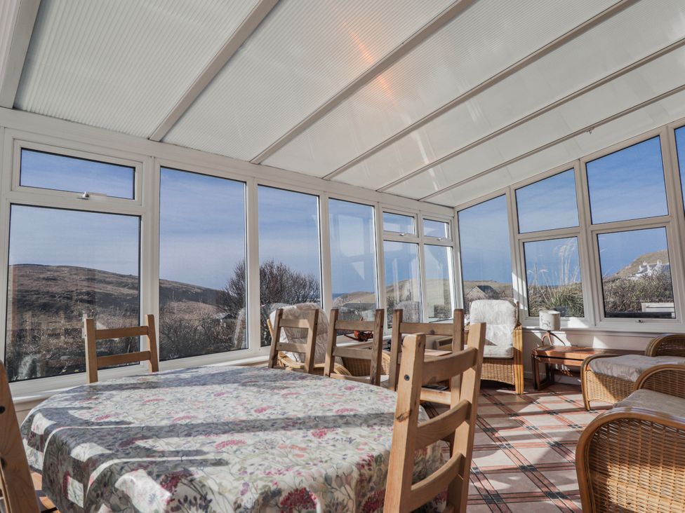 A conservatory with a table and chairs at An Grianan in Kinlochbervie