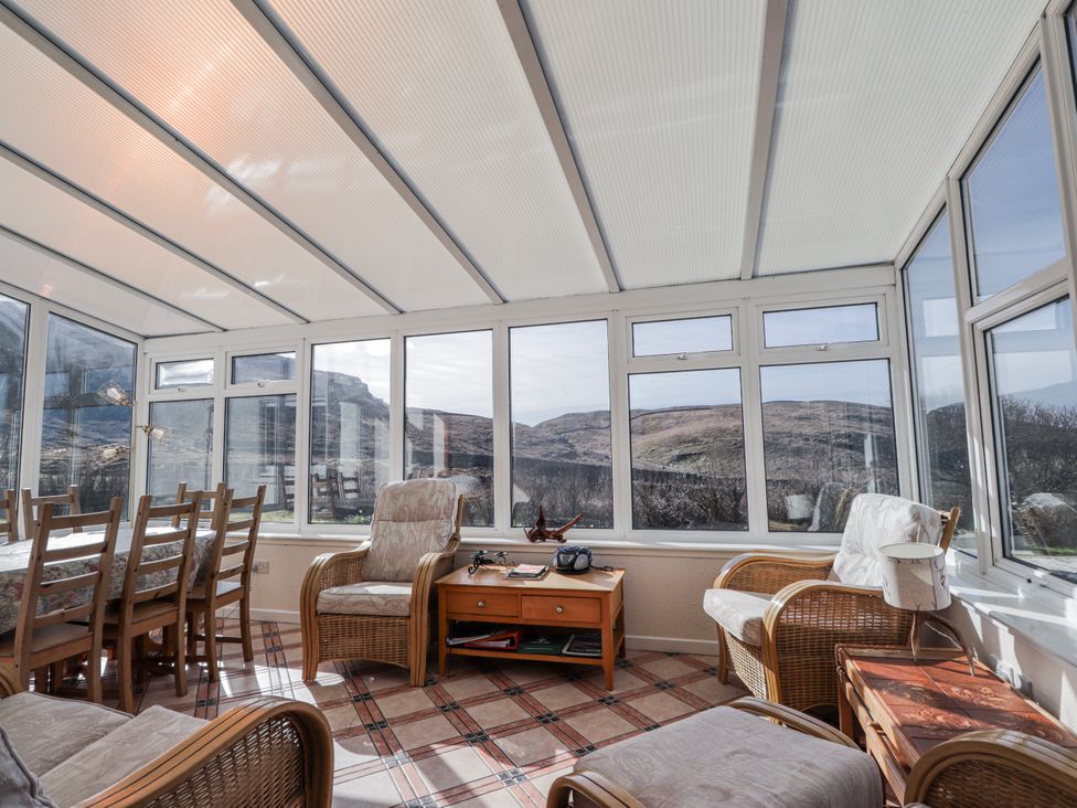 A conservatory with a table and chairs at An Grianan in Kinlochbervie