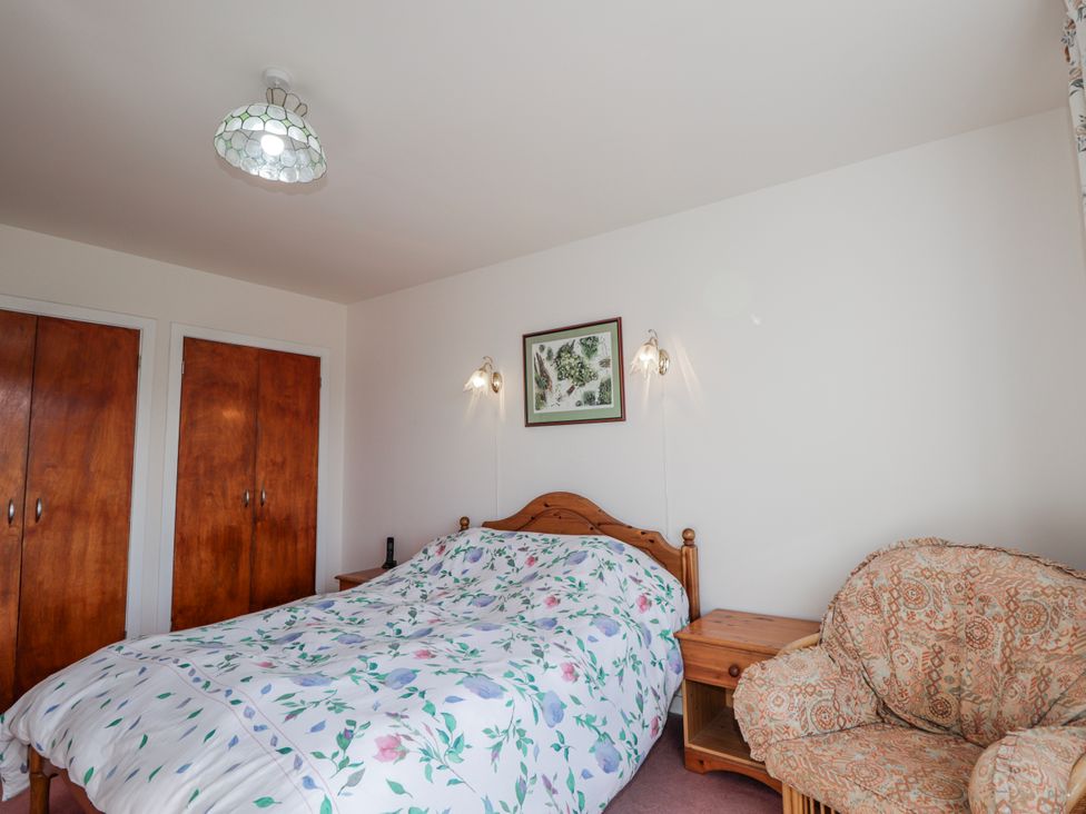 A bedroom with a bed and nightstand at An Grianan in Kinlochbervie