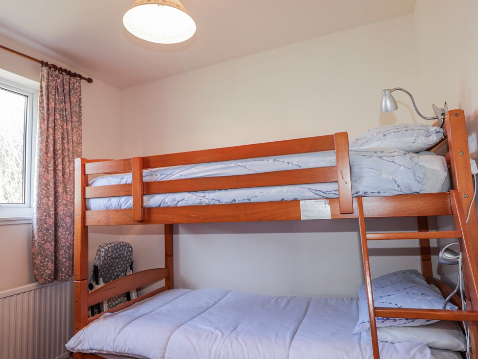A bedroom with a bunk bed and a window at An Grianan in Kinlochbervie