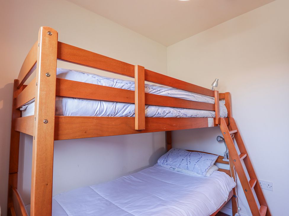 A bunk bed with upper and lower mattresses in the bedroom at An Grianan, Kinlochbervie