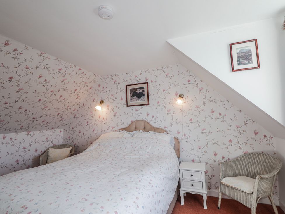 A bedroom with a bed and bedside table at An Grianan in Kinlochbervie