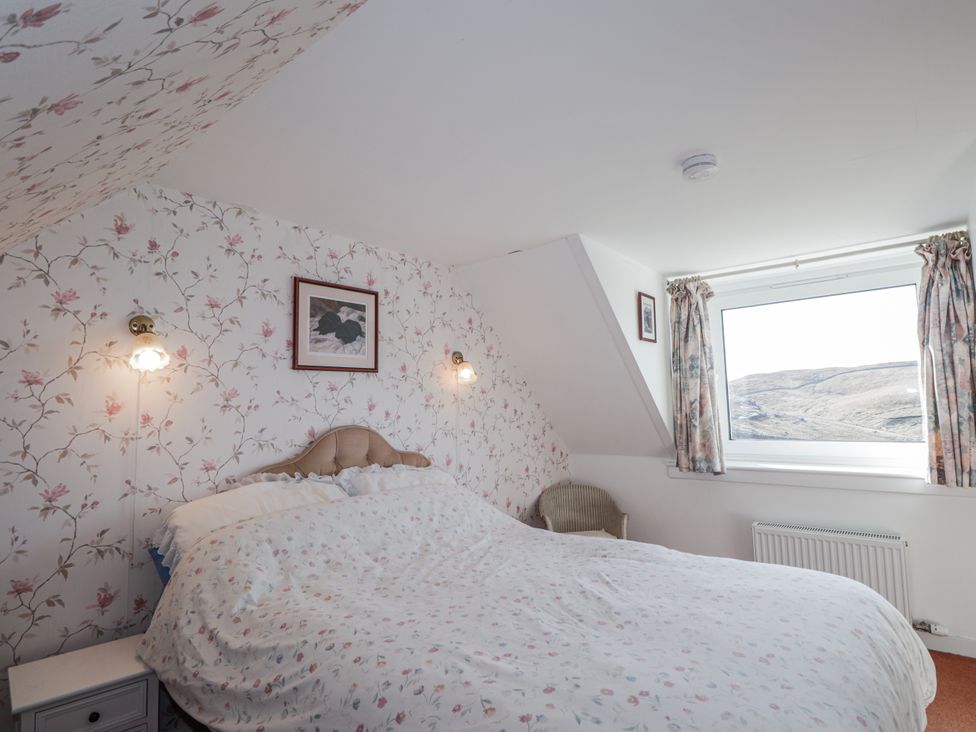 A bedroom with a bed and nightstand at An Grianan in Kinlochbervie